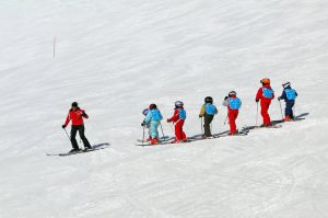 children following an instructor on a ski slope